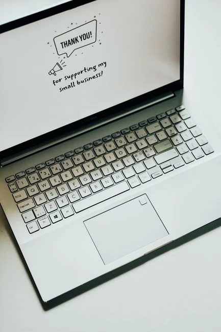 Business professional using a tablet and laptop with a hot drink, focusing on digital content review.